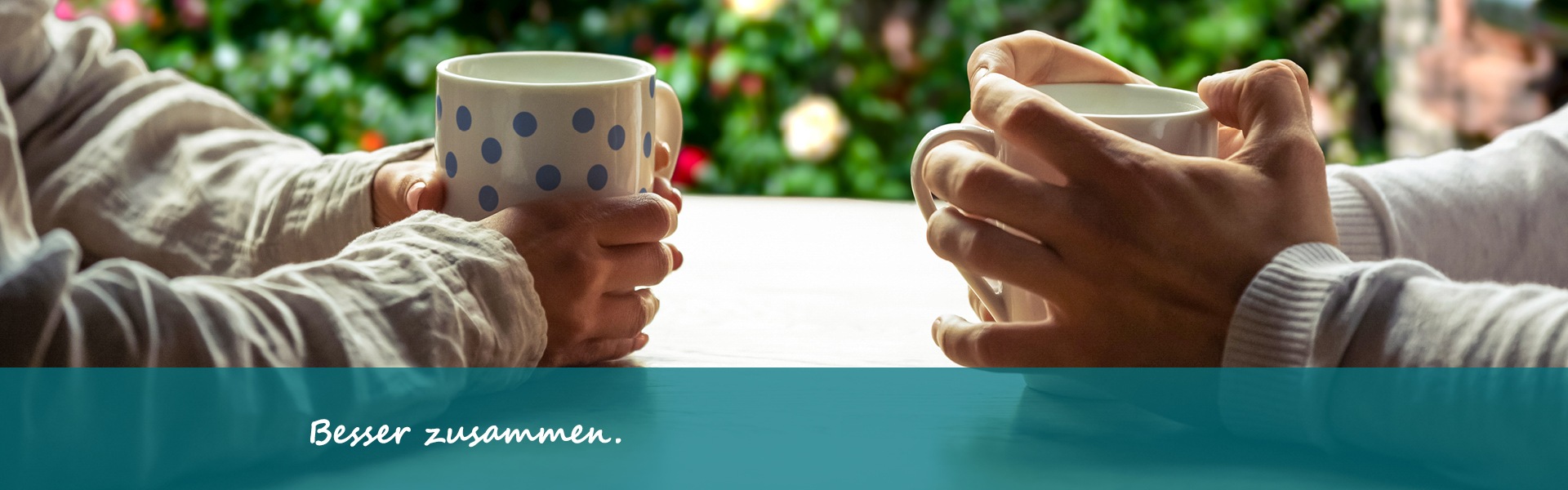 Die Hände von 2 Menschen sind zu sehen. Beide halte eine Kaffeetasse fest.
